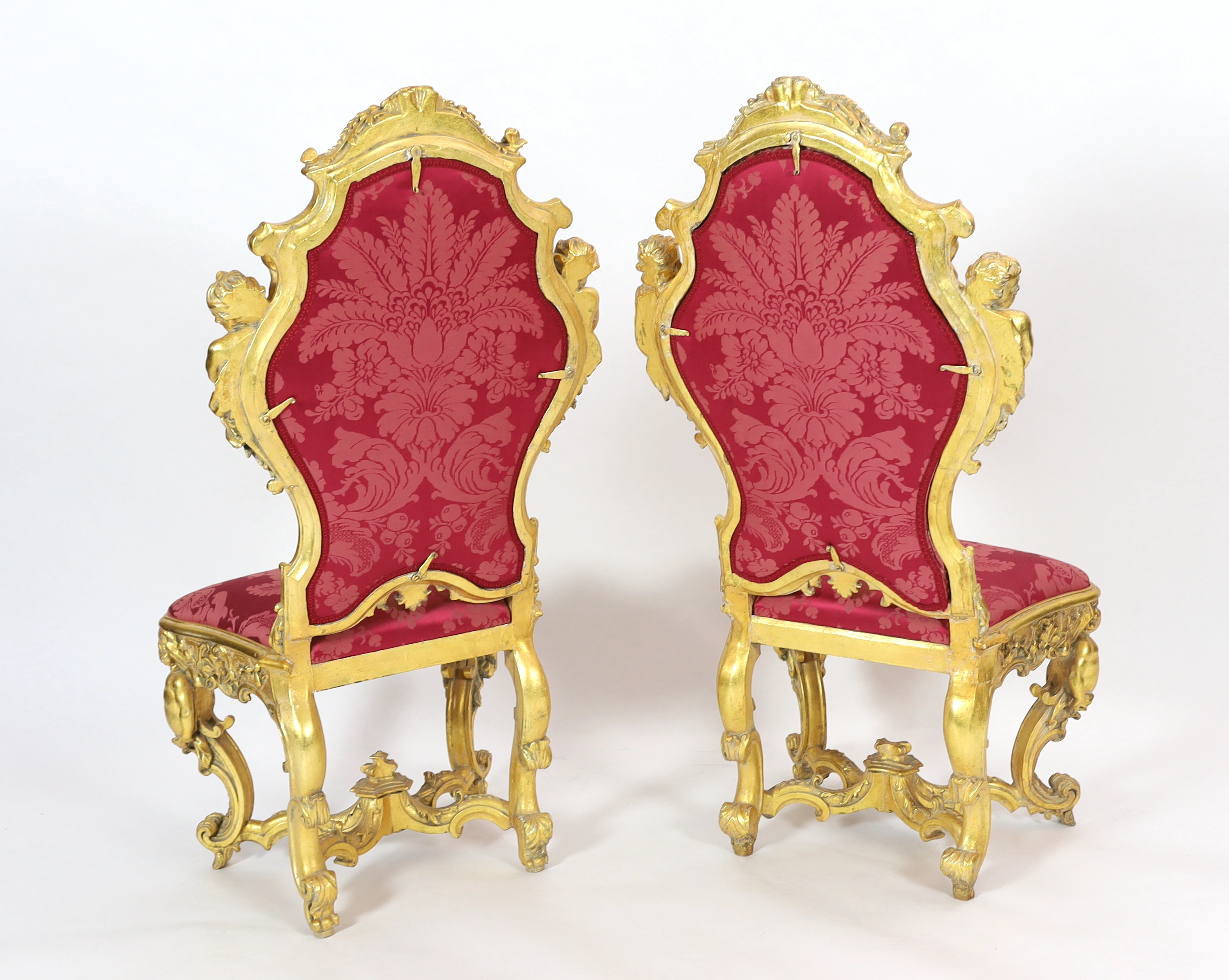 An important pair of late 18th century Venetian carved baroque giltwood throne chairs, the seats and backs upholstered in red floral silk. c.1770, 64cm wide, 55cm deep, 132cm high, Please note this lot attracts an additi